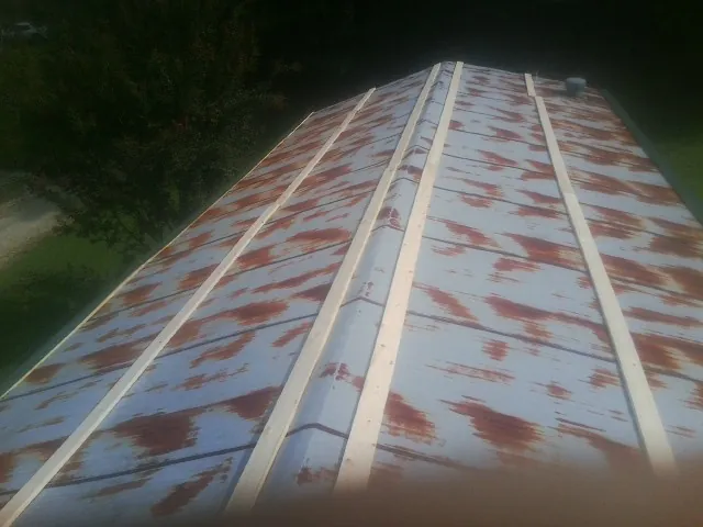 Rusted metal roof panels with new wood purlins before replacement — Storm Damage Roof Repair in New Johnsonville by Roofing Brothers