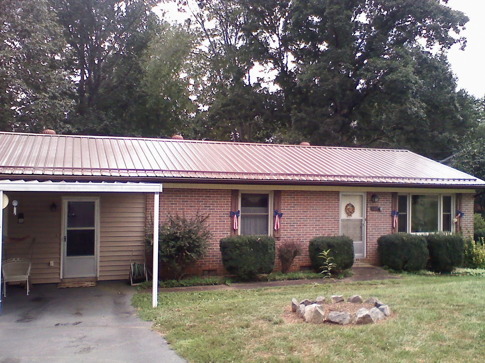 Bronze metal roof and carport on a brick ranch home — Roof Repair work by our crew in New Johnsonville